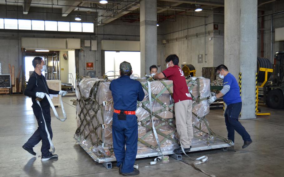 A team of aircraft services specialists working with the 733rd Air Mobility Squadron on Kadena Air Base, Okinawa, secures a pallet of Burger King buns for transport headed to Andersen Air Force Base, Guam. Due to unseen circumstances, the American Bakery in Guam could not deliver their obligated buns supply to all of the Burger King restaurants on the island, to include the one on Andersen AFB, which caused a ripple effect within the Exchange. (U.S. Army Photo by Staff Sgt. Mark A. Kauffman)