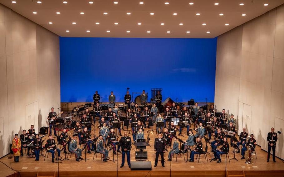 U.S. Marines with the III Marine Expeditionary Force (MEF) and members of the Japan Ground-Self Defense Force 15th Brigade bands pose for a photo at Tedako Hall in Urasoe, Okinawa, Japan, April 16, 2021. The bands' harmonious performance was a display of the III MEF and 15th Brigade bands' alliance and unity within the musical arts. The annual concert was performed virtually and the recording will debut on social media platforms within the coming weeks. (U.S. Marine Corps photo by Cpl. Terry Wong)