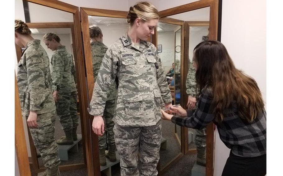 Stacey Butler, right, a clothing designer with the Air Force Life Cycle Management Center's Air Force Uniform Office, measures Capt. Taylor Harrison's maternity Airman Battle Uniform. The new uniforms were designed and developed by the office and are available to pregnant Airmen around the world. (U.S. Air Force photo by Brian Brackens)