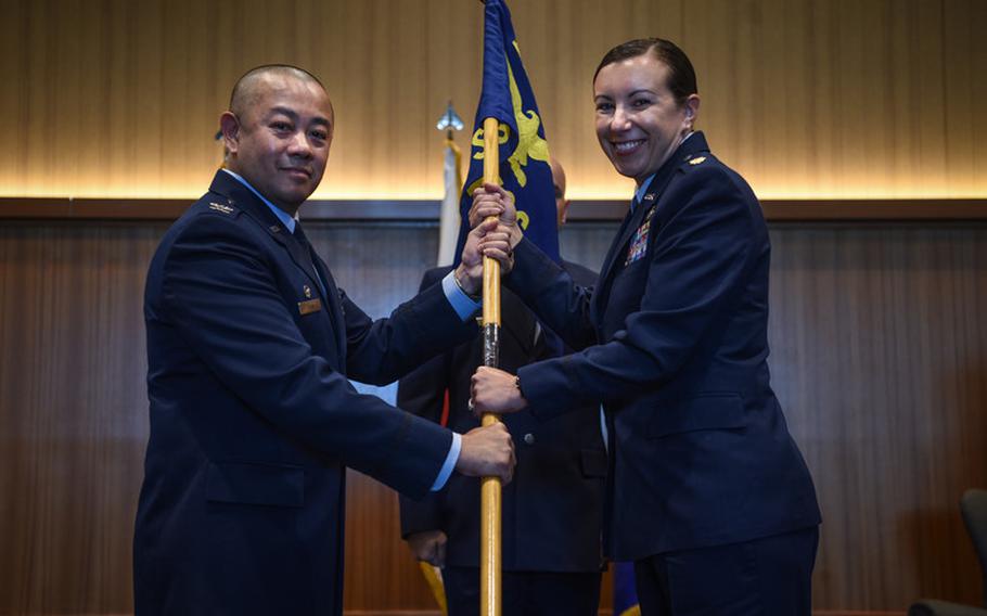 U.S. Air Force Col. Thang T. Doan, 18th Mission Support Group commander, passes the 718th Force Support Squadron guideon to Maj. Jama Stillwell, 718th FSS commander, during the 718th FSS activation ceremony at Kadena Air Base, July 16,th 2019. (U.S. Air Force photo by Senior Airman Kristan Campbell)