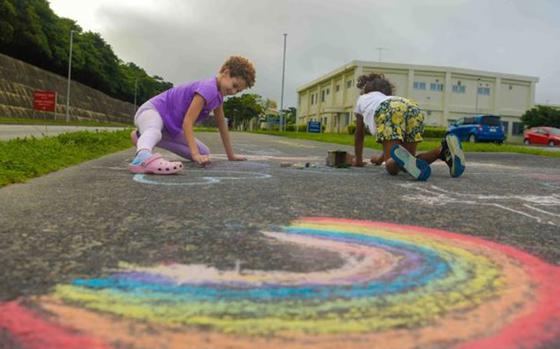 Pride Month Color Run participants decorate the track outside the U.S. Naval Hospital Okinawa, Camp Foster, Japan, June 8, 2024.