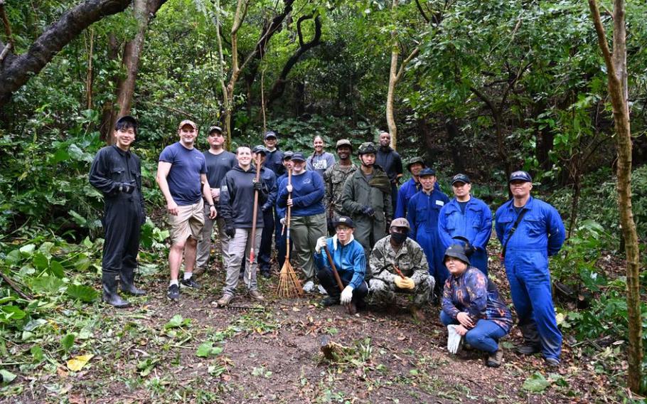 Volunteers from the U.S. Navy and Japan Maritime Self-Defense Force pause after clearing foliage around the Chibu nu Ka sacred well as part of the “Jungle Attack” community relations project, conducted annually to clear jungle overgrowth and improve access to ancestral tombs and other sacred sites on White Beach Naval Facility.