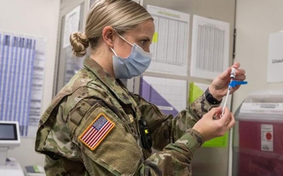 Army Capt. Patricia Nolan, a nurse, prepares vaccinations of the Pfizer-BioNTech COVID-19 at Madigan Army Medical Center on Joint Base Lewis-McChord in Washington on Dec. 16. Madigan is part of DHA’s Puget Sound market, scheduled to begin transition to the DHA in February. (Photo by John Wayne Liston, Madigan Army Medical Center.)