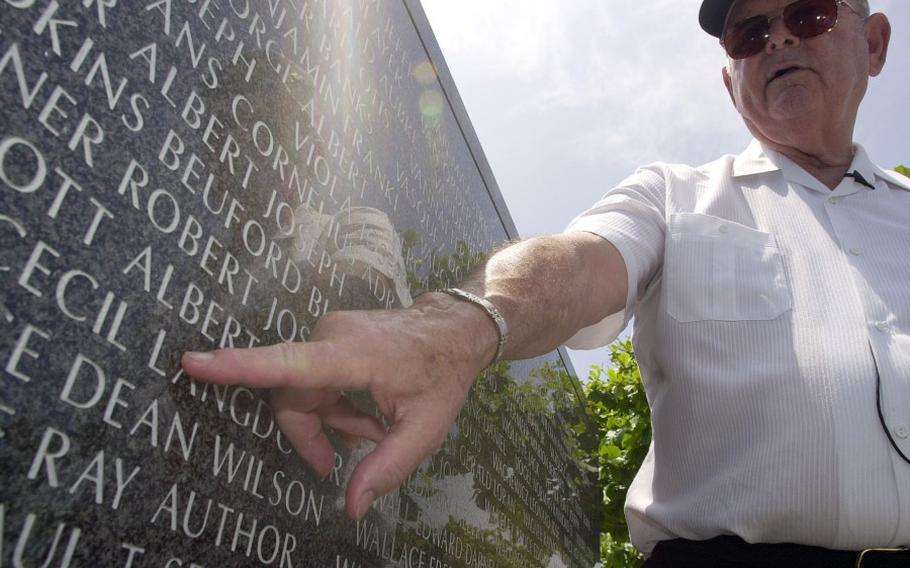 Medal of Honor recipient Robert Bush traces his finger under the name of Albet Walcott at the Cornerstones of Peace Monument in Itoman, Okinawa, June 15, 2003. Walcott was a friend and comrade-in-arms who died during the Battle of Okinawa. STARS AND STRIPES