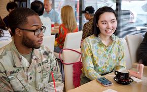 Spec. Cameron S. Henley, 10th Support Group, engages with Okinawan citizens during a recent Asakatsu engagement between 10th Support Group Soldiers and locals in Yomitan, Okinawa.