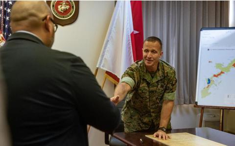 Photo Of U.S. Marine Corps Maj. Gen. Stephen Liszewski, commanding general of Marine Corps Installations Pacific, greets Zach Dungca, a supervisor with the Family Advocacy Program, Behavioral Health, Marine Corps Community Services Okinawa, before the signing of the Child Abuse Prevention Month proclamation on Camp Foster, Okinawa, Japan, April 1, 2024.