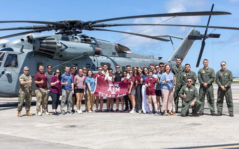 Photo Of U.S. Marines with 1st Marine Aircraft Wing and Texas A&M University Reserve Officer Training Corps students pose in front of a CH-53E Super Stallion helicopter on Marine Corps Air Station Futenma, Okinawa, Japan.