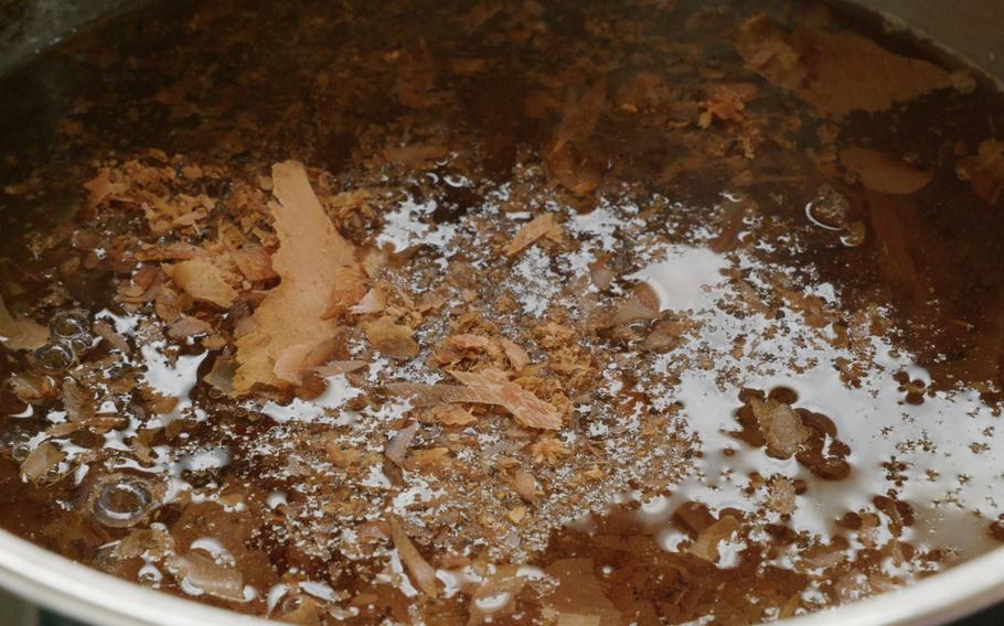 Cook dashi (Japanese soup stock) by boiling bonito flakes in hot water. Remove the flakes by pour the broth through a strainer.