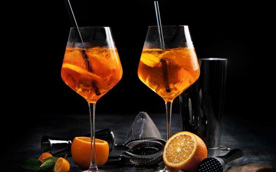 Aperol spritz cocktail served on dark background.