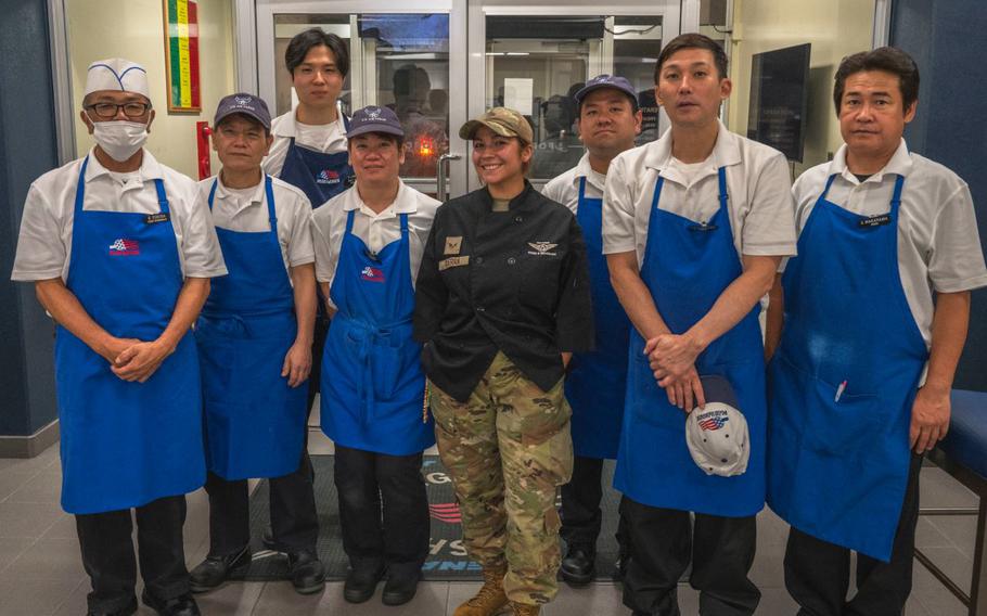 Members of the 18th Force Support Squadron food services flight pose for a photo during the midnight service at the Marshall Dining Facility on Kadena Air Base, Japan.
