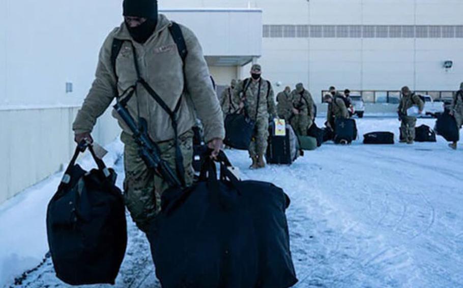 U.S. Airmen carry their deployment gear as they arrive at the Joint Mobility Complex for exercise Polar Force at Joint Base Elmendorf-Richardson, Alaska, Nov. 16, 2021. Polar Force is a two-week exercise designed to test JBER’s mission readiness while strengthening and developing the skills service members require when facing adverse situations.