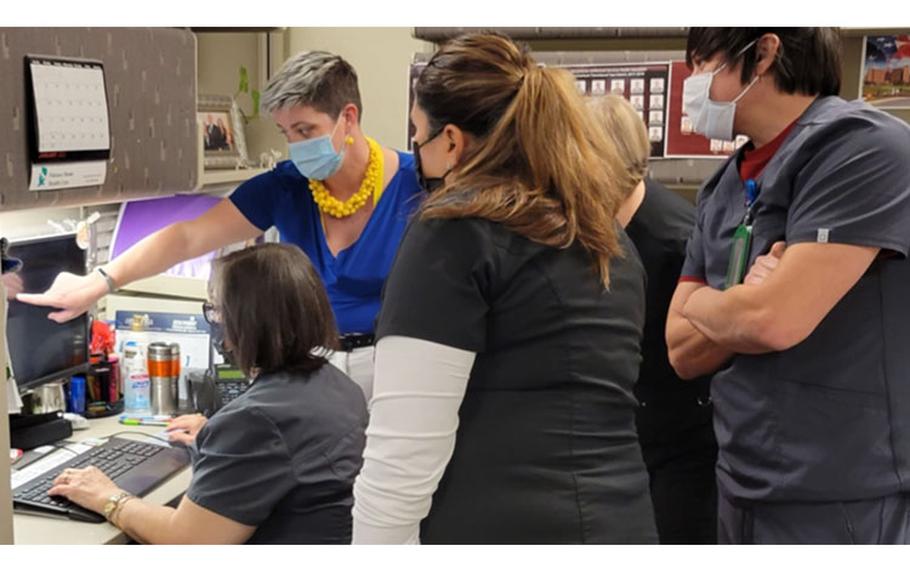 Lisa Clark, a Pay it Forward team member from Naval Hospital Twentynine Palms, shows Brooke Army Medical Center case managers how to input data into the MHS GENESIS system at BAMC, Joint Base San Antonio-Fort Sam Houston, Texas, Jan. 22, 2022. Pay it Forward team members come from sites that have implemented MHS GENESIS to help with the transition to the new system. (Photo by Lori Newman, Brooke Army Medical Center Public Affairs)