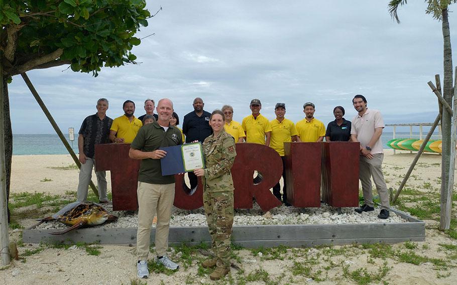 Army MWR Okinawa Torii Station group photo as Stars and Stripes Pacific Commander Lt. Col. Marci Hoffman presents award.