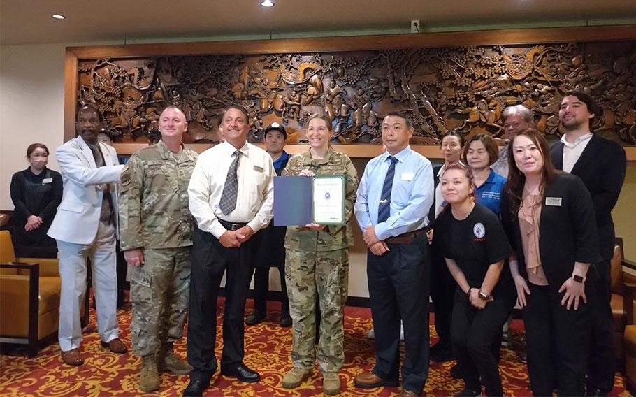 Kadena Officers’ Club staff group photo as Stars and Stripes Pacific Commander Lt. Col. Marci Hoffman presents award.