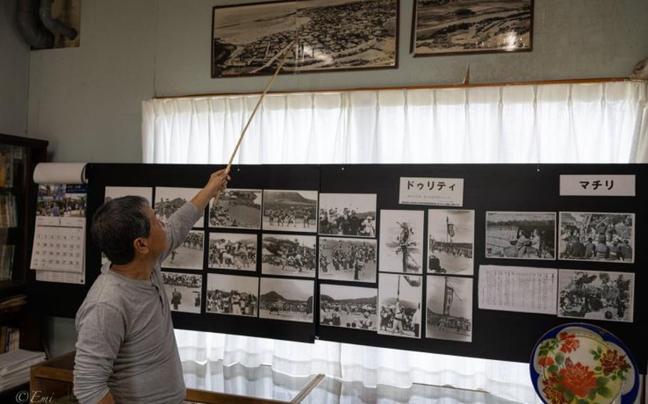 Mr. Ryuichi Ikema, a director of the folk museum, points at one of the archive photos of the Sonai region taken from the 85-meter-high cliff.