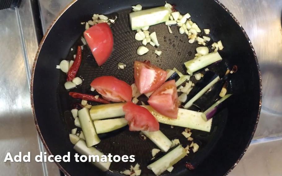 Add sliced tomatoes and eggplants into the pan and fry.