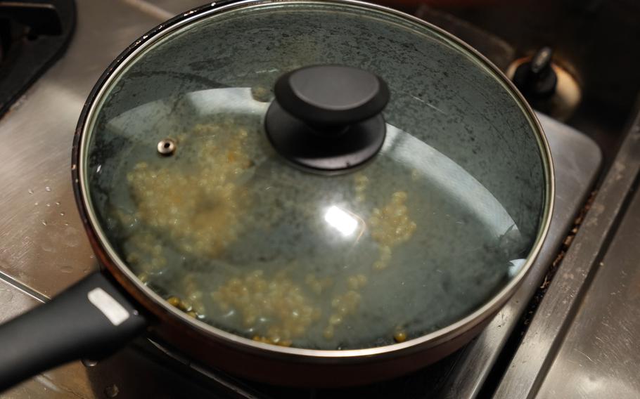 3 When the popcorn starts bouncing, shake the pan.