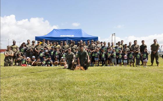 U.S. Marines with Marine Corps Installations Pacific and students from Kamimotobu After-School Children’s Club pose for a group photo.