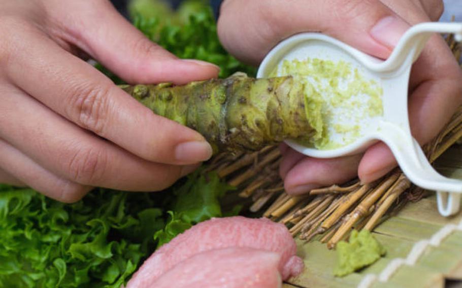 a person grating wasabi.