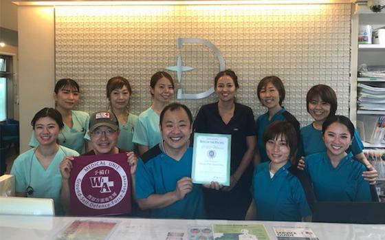 Photo Of Okinawa White Dental Clinic staff smilingly pose.