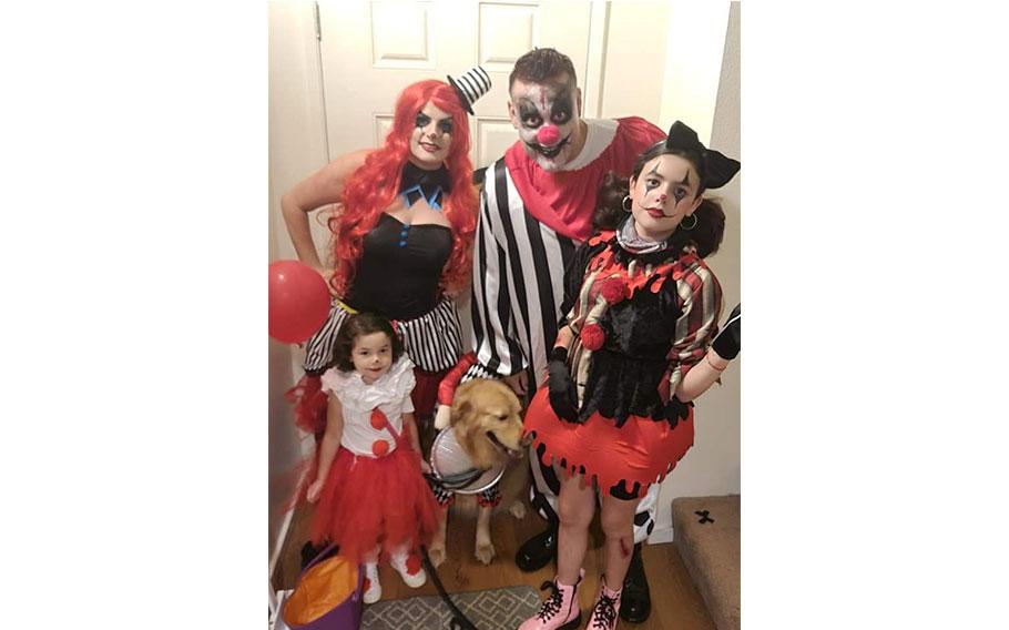 four people wearing costumes of crowns and a dog.