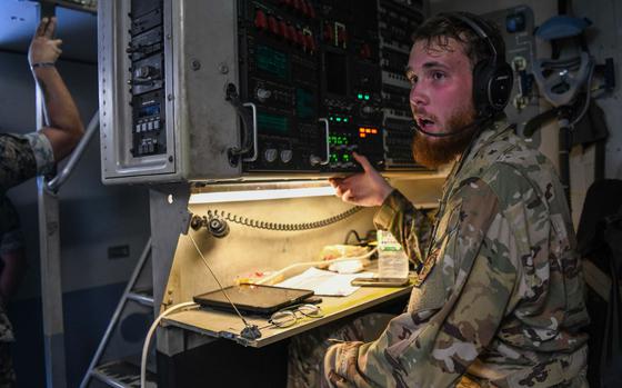 Photo Of U.S. Air Force Airman 1st Class Yosef Linn, 16th Airlift Squadron loadmaster, simulates a landing call in a U.S. Air Force C-17 Globemaster III during a joint force ground training at Kadena Air Base, Japan, Sept. 9, 2024. Loadmasters with the 16th AS conducted hands-on loading operations for U.S. Marine Corps Marines with the III Marine Expeditionary Force and 3rd Landing Support Battalion, simulating transportation of ground vehicle cargo.