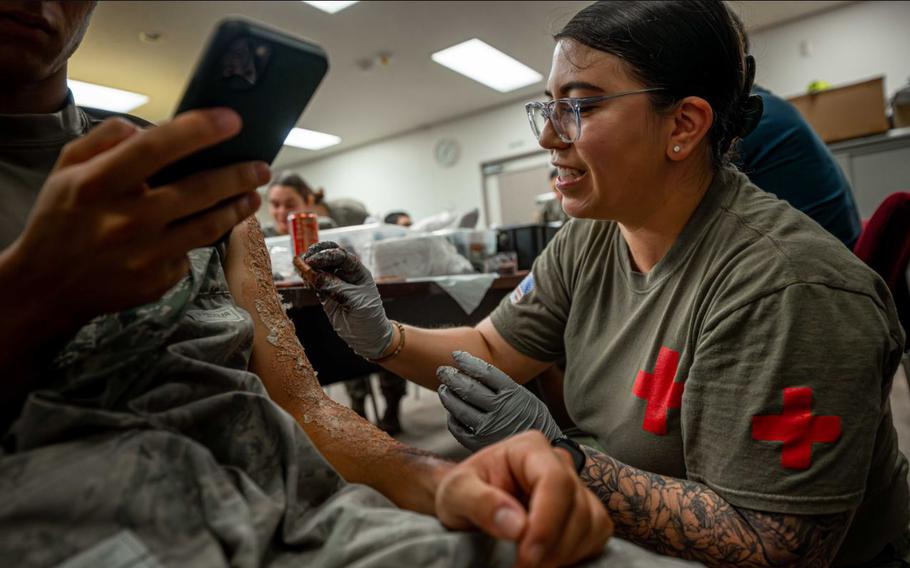 U.S. Air Force Staff Sgt. Sarah Jacinto, 18th Medical Group diagnostic imaging noncommissioned officer in charge, applies moulage to a volunteer for a simulated mass casualty exercise at Kadena Air Base, Japan, May 8, 2025. 