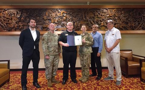 Photo Of Chili’s Grill & Bar staff group photo as Stars and Stripes Pacific Commander Lt. Col. Marci Hoffman presents award.