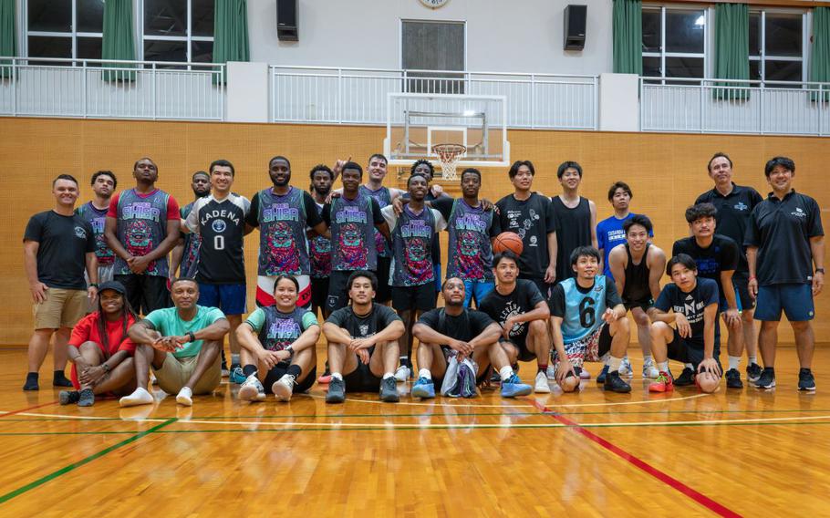 U.S. Air Force Airmen with the 18th Communications Squadron basketball team and the Okinawan prefectural representative team pose for a group photo.