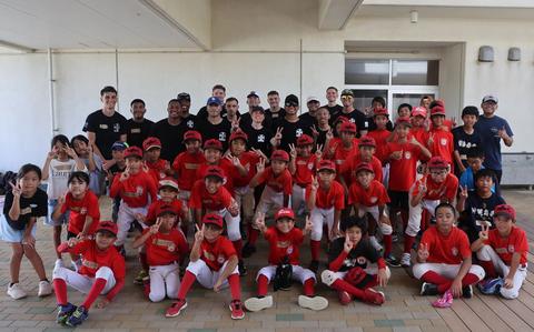 Photo Of U.S. Marines with Marine Light Attack Helicopter Squadron 169, Marine Aircraft Group 36, 1st Marine Aircraft Wing pose for a photo with local youth baseball team.