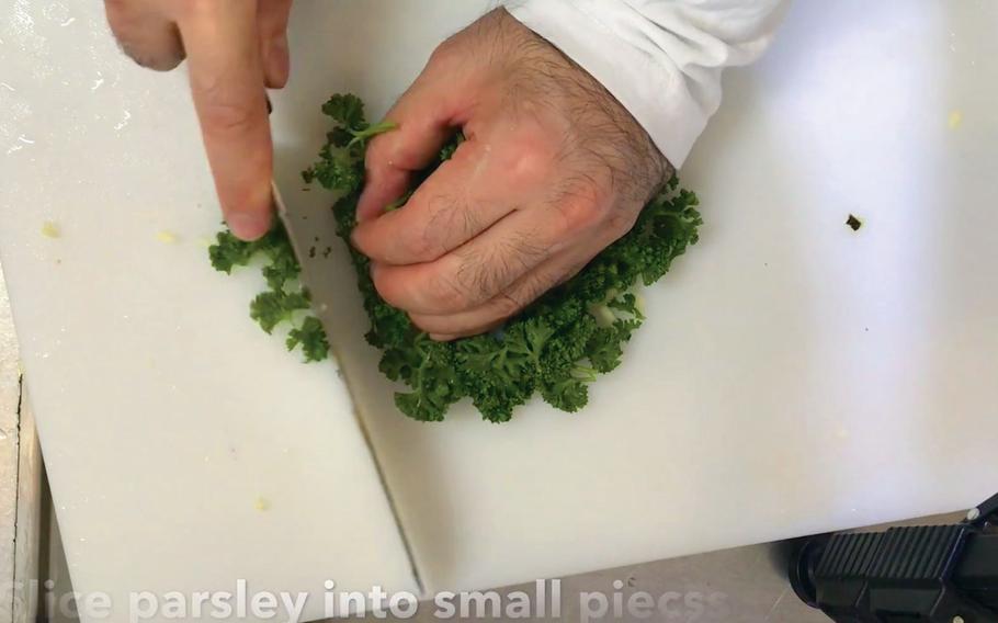 Slicing parsley into small pieces.