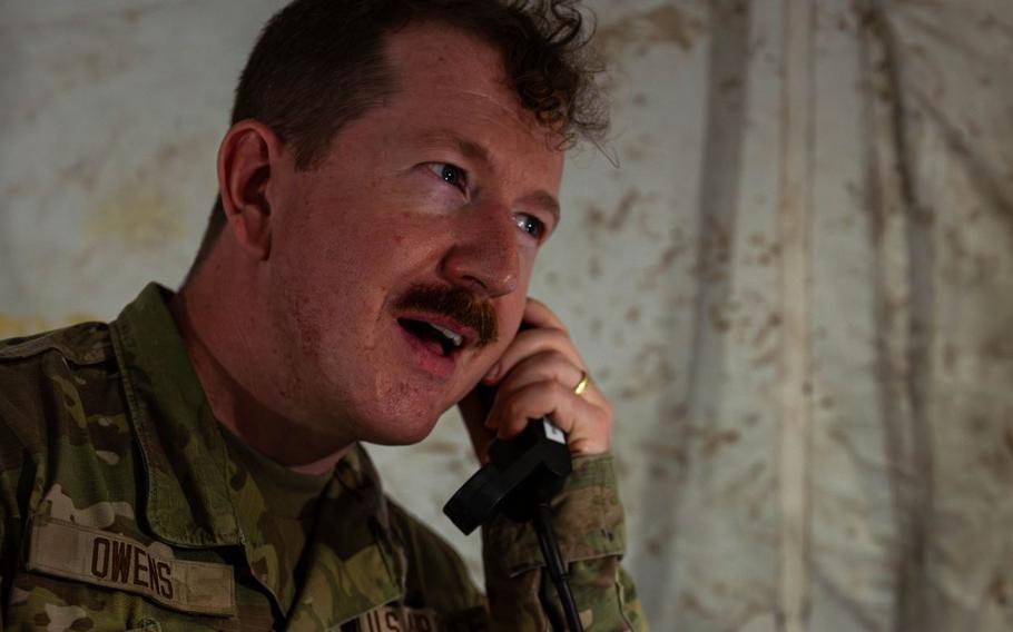U.S. Air Force Senior Airman Kyle Owens, 18th Communication Squadron expeditionary communications specialist, speaks on a phone.