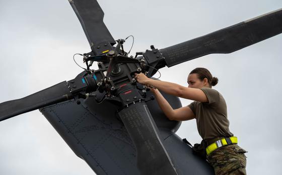 U.S. Air Force Airman 1st Class Shiloh Avery installs weights on a U.S. Air Force HH-60W Jolly Green II.