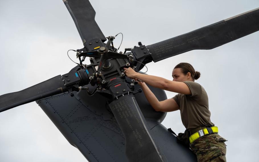 U.S. Air Force Airman 1st Class Shiloh Avery installs weights on a U.S. Air Force HH-60W Jolly Green II.