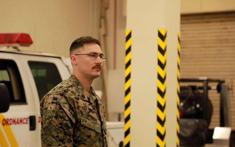 Sgt. Joshua Upright gives a briefing. A vehicle can be seen behind him.