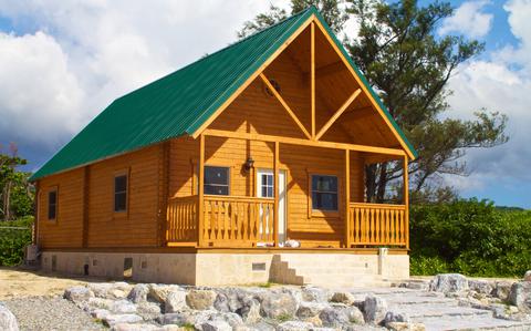 Photo Of One of the lodges at Okuma Recreation Annex. There are some trees behind it. The weather is fine, but cloudy.