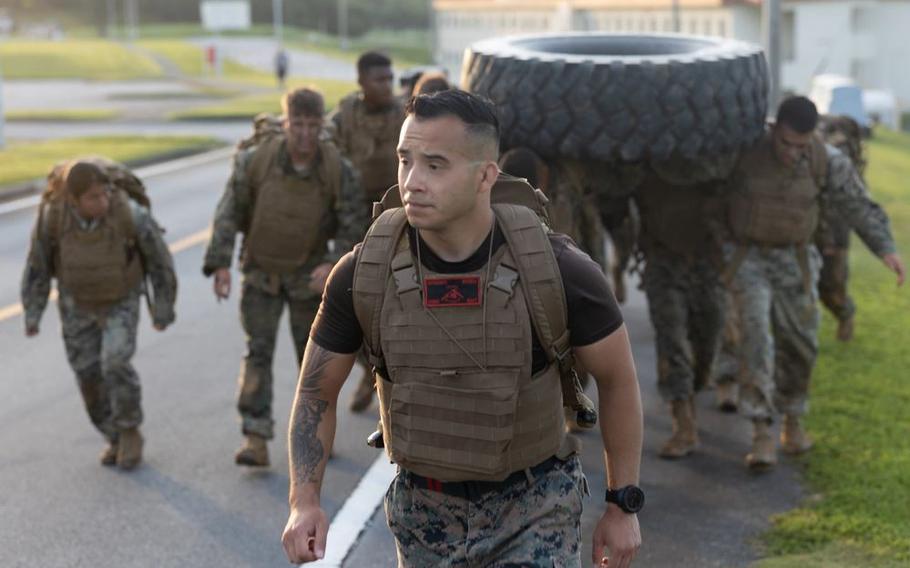 Sgt. Jacob Roses leads his team to the next event. some of his team members is carrying a huge tire.