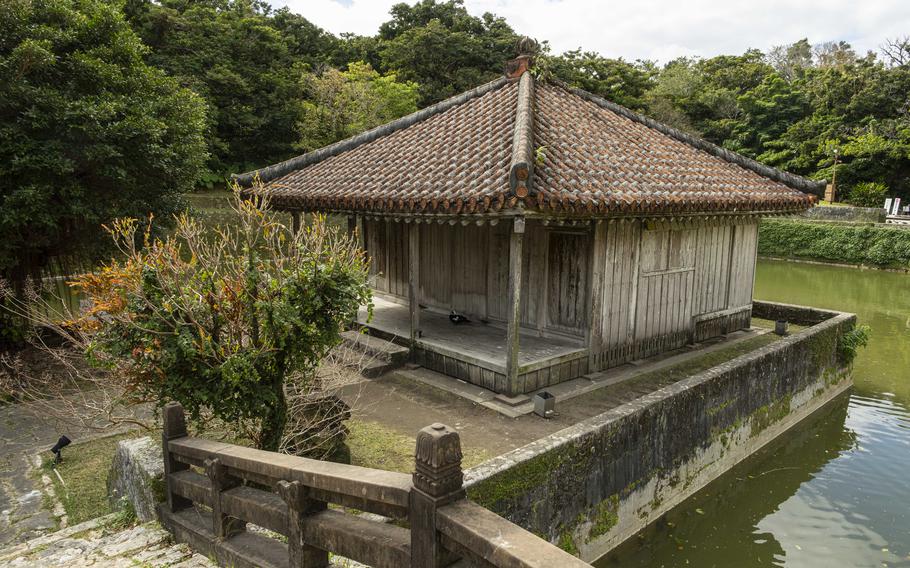 an Okinawan style house can be seen by the pond.
