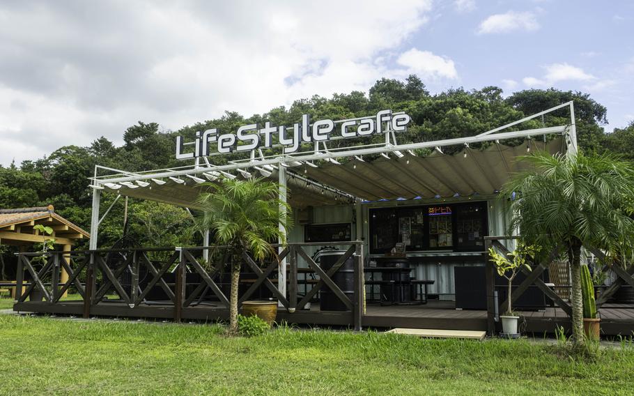 front photo of Life Style Café. There are some palm trees.