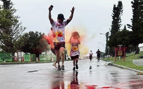 Photo Of Participants run through a cloud of colored powder during the Army Emergency Relief campaign 5K Color Run at Torii Station, Okinawa, Japan, March 15, 2025.