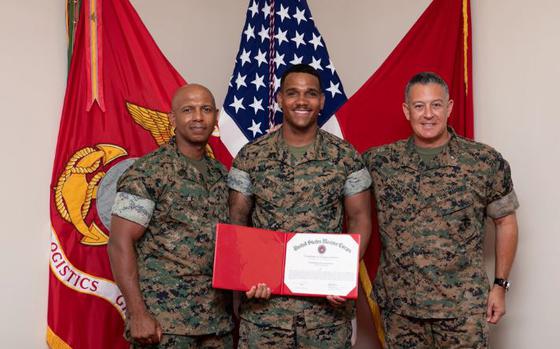 Photo Of U.S. Marine Corps Brigadier General Adam Chalkley, right, the commanding general of 3rd Marine Logistics Group (3rd MLG), Cpl. Ashton Wilson, middle, a metalworker with 3rd Maintenance Battalion, Combat Logistics Regiment 3, 3rd MLG, and Sgt. Maj. Dennis Turner, left, the sergeant major of 3rd MLG, pose for a photo on Camp Kinser, Okinawa, Japan, August 2, 2024. Wilson was recognized as the non-commissioned officer of the quarter for performing above and beyond the expectations set by his unit. Wilson is a native of Virginia.