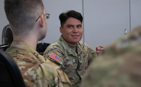 Photo Of SPC Angel Mendiola participates in a discussion during the Air Force’s Airman Leadership Course in Okinawa. He has a seat and talking to one of the participants.