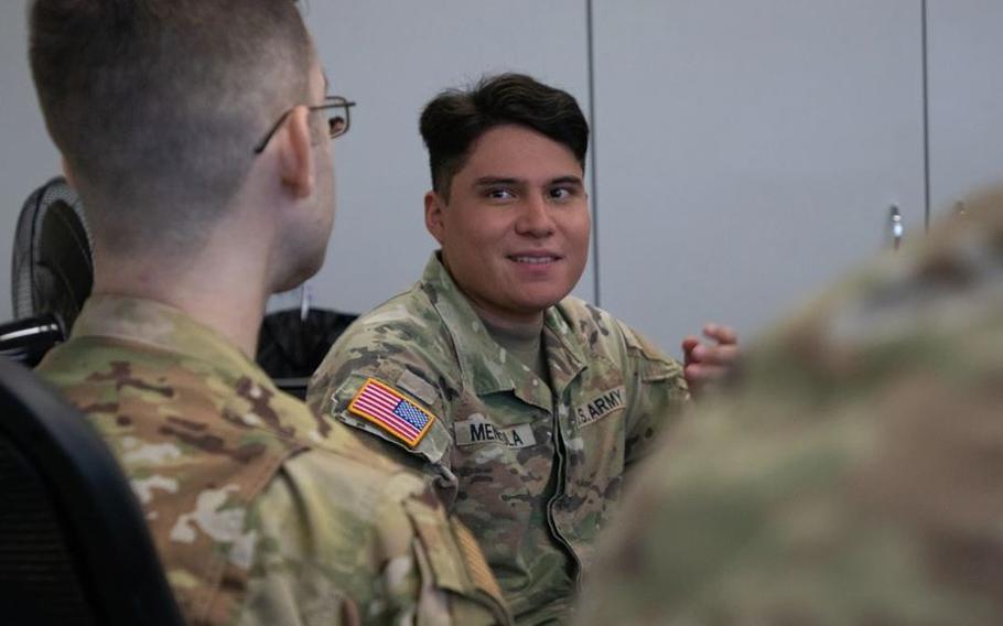 SPC Angel Mendiola participates in a discussion during the Air Force’s Airman Leadership Course in Okinawa. He has a seat and talking to one of the participants.