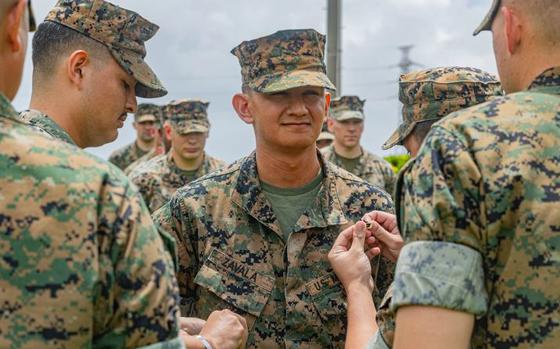 Photo Of U.S. Marine Corps Cpl. Adrian Zavala, a command and control picture client (C2PC) operator with the 3rd Marine Expeditionary Brigade and a native of California, gets pinned to the rank of corporal by those who positively impacted him during his promotion and reenlistment ceremony at Camp Courtney, Okinawa, August 19, 2024. The ceremony marked Cpl. Zavala’s entrance into the noncommissioned officer (NCO) ranks while also ensuring, through reenlistment, his commitment to the Marine Corps. With this promotion comes greater responsibilities and expectations as NCOs serve as the backbone of the Marine Corps and as a vital link between officers and enlisted Marines.