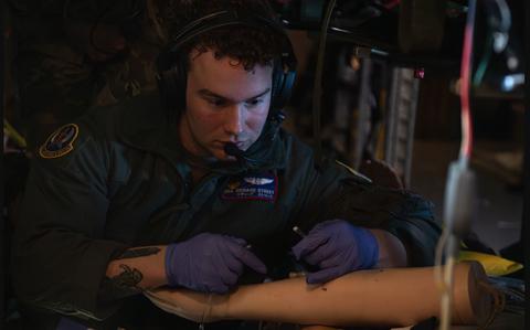 Photo Of Senior Airman, Richard Street inserts an intravenous tube on a simulated patient.