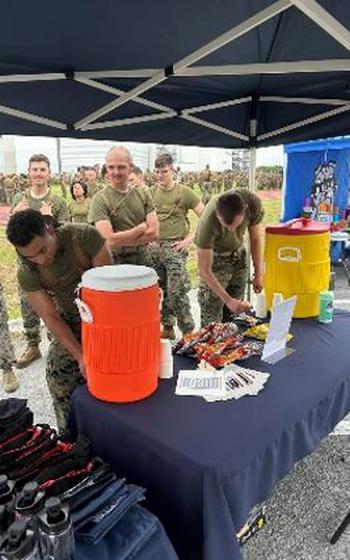 Marines participating in 3D Marine Logistics Group Annual Field Meet receive hydration and snacks from the USO tent.