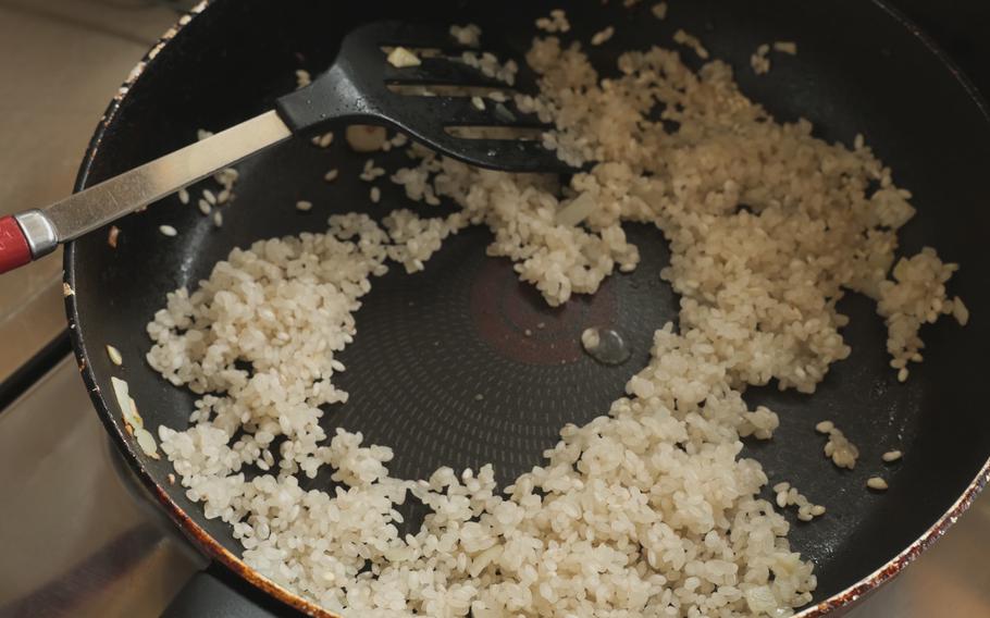 Fry uncooked rice in the frying pan. Once the rice becomes transparent, put in white wine (or sake), salt, pepper, water, and tomato sauce. Mix them gently.