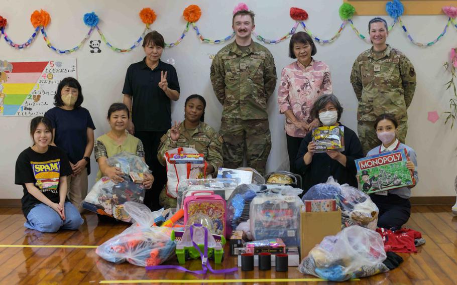 U.S. Air Force Airmen with the 18th Wing and 353rd Special Operations Wing and children’s support facility staff members pose for a group photo during a Christmas in July event at a child support facility outside Kadena Air Base, Japan, July 23, 2024.The program is a volunteer and donation-based event initiated to provide aid to the local Okinawan children’s support facilities.