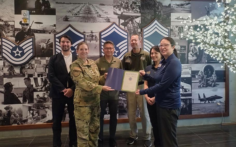 Kadena ITT group photo as Stars and Stripes Commander Lt. Col. Marci Hoffman and SSP staff Kajito Tanaka present best travel agency award to Kadena ITT staff.