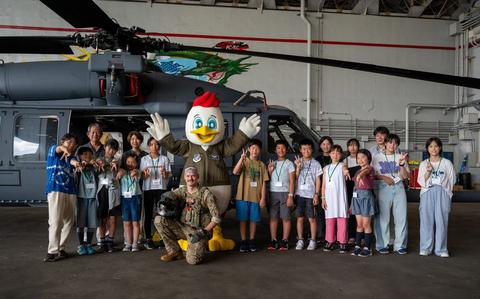 Photo Of U.S. Air Force Capt. Tyler Wright, 33rd Rescue Squadron HH-60W Jolly Green II pilot, 18th Wing mascot, Kappy and Achi-Mura students and teachers pose for a group photo in front of an HH-60W at Kadena Air Base, Japan, Aug. 4, 2025. 